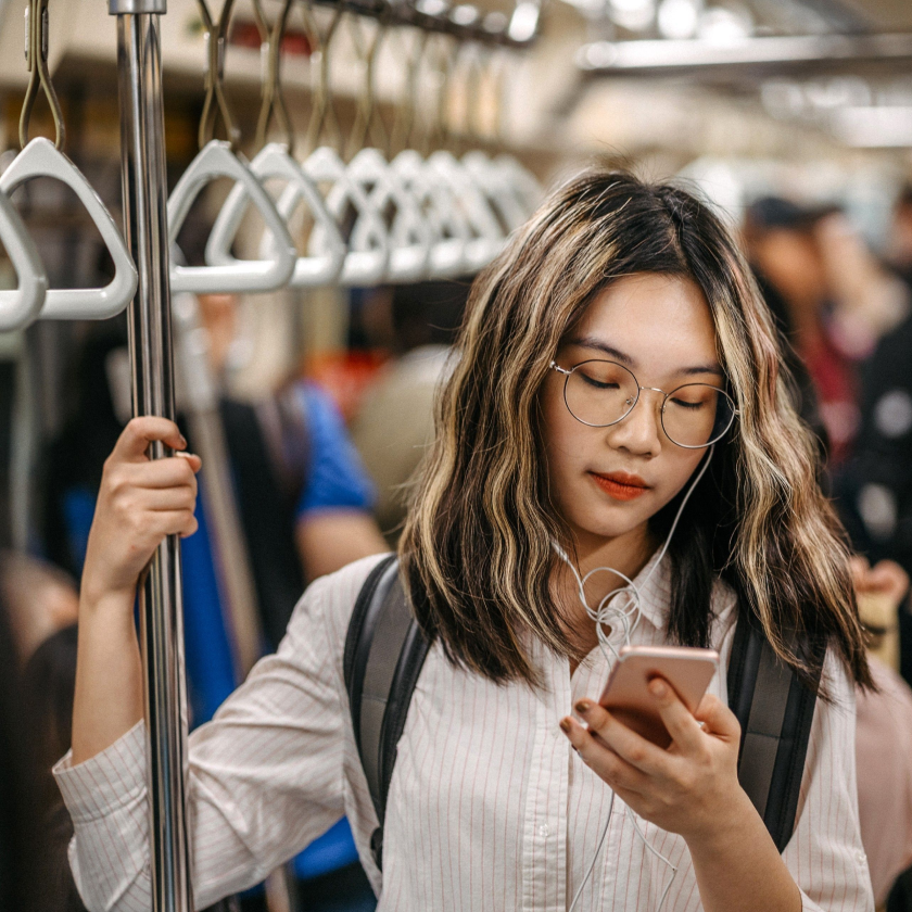 Photograph of a commuter using their smartphone to send a large video in a text message.
