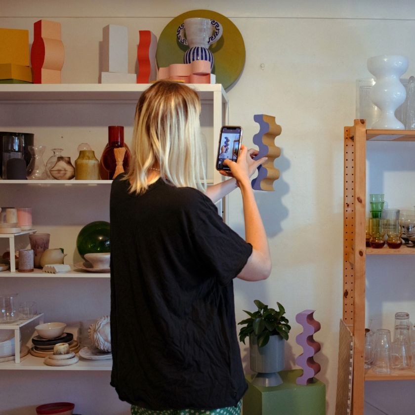 A small business owner takes pictures of a product for their ecommerce store