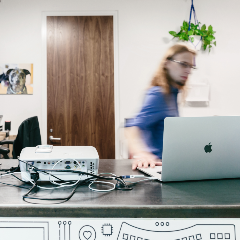 A person in an office works on their Mac computer to back up their files.