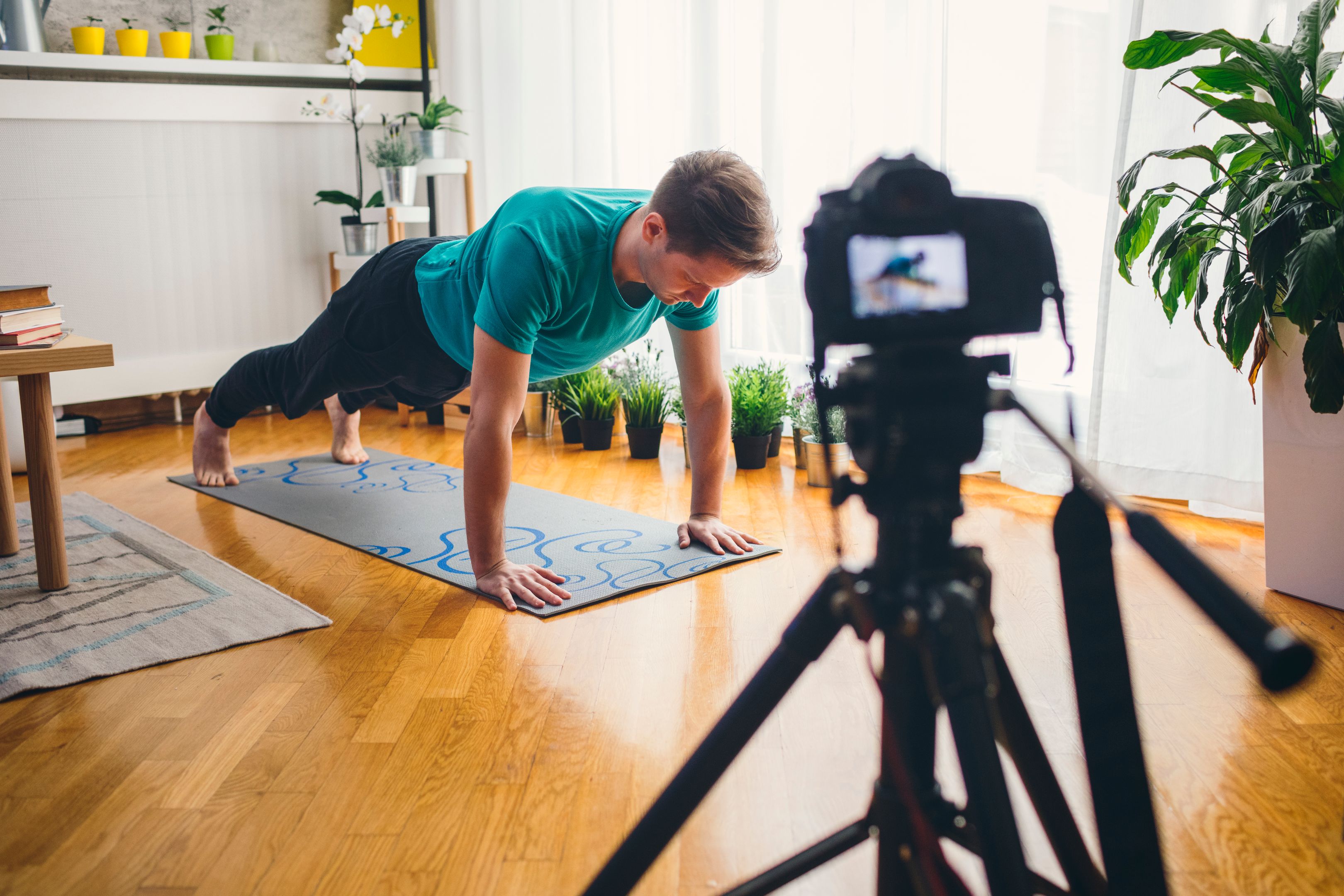 A YouTuber films themselves practicing yoga at home.