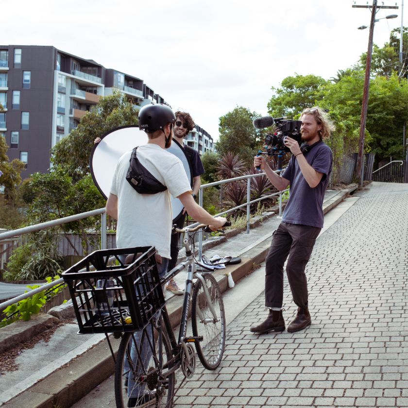 Three people film a marketing video outside.