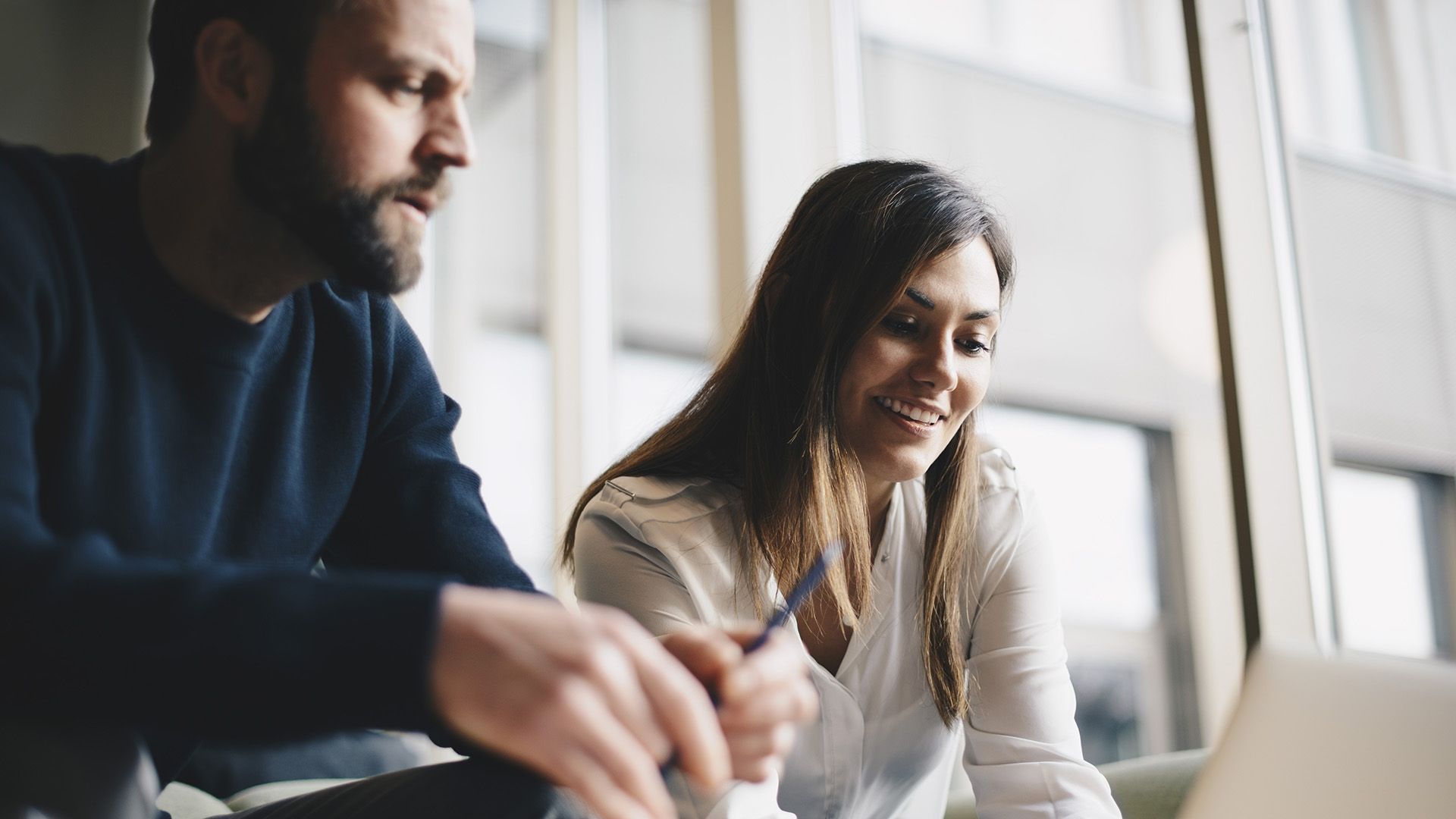 Two colleagues discuss their modular content strategy in a breakout area.