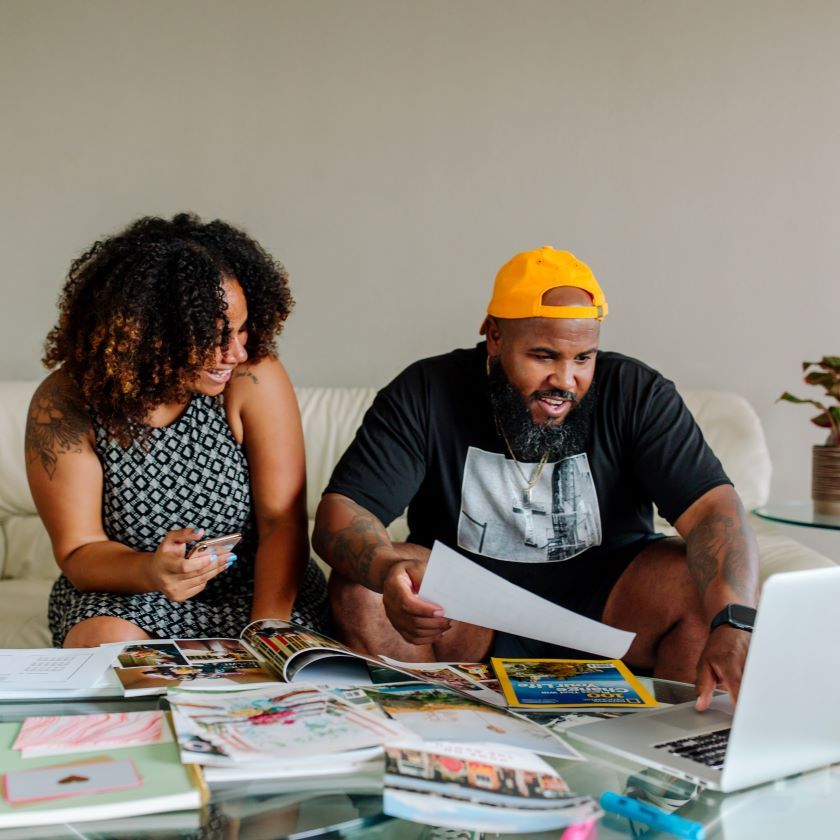 Couple planning at a table using Dropbox to organize their files.