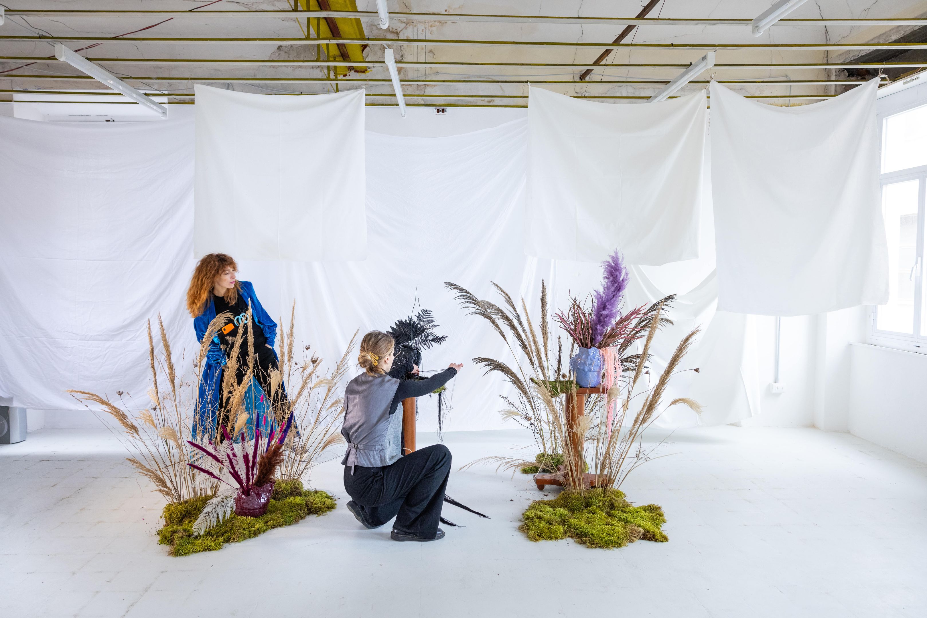 Two individuals organizing a creative studio setup for photography.