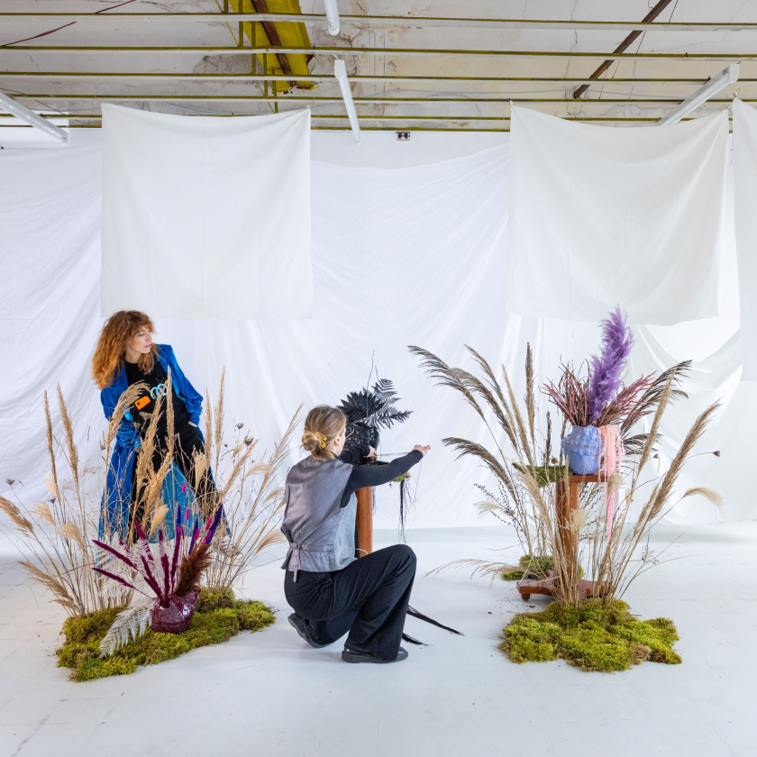 Two individuals organizing a creative studio setup, symbolizing the importance of backing up photo memories for safekeeping.