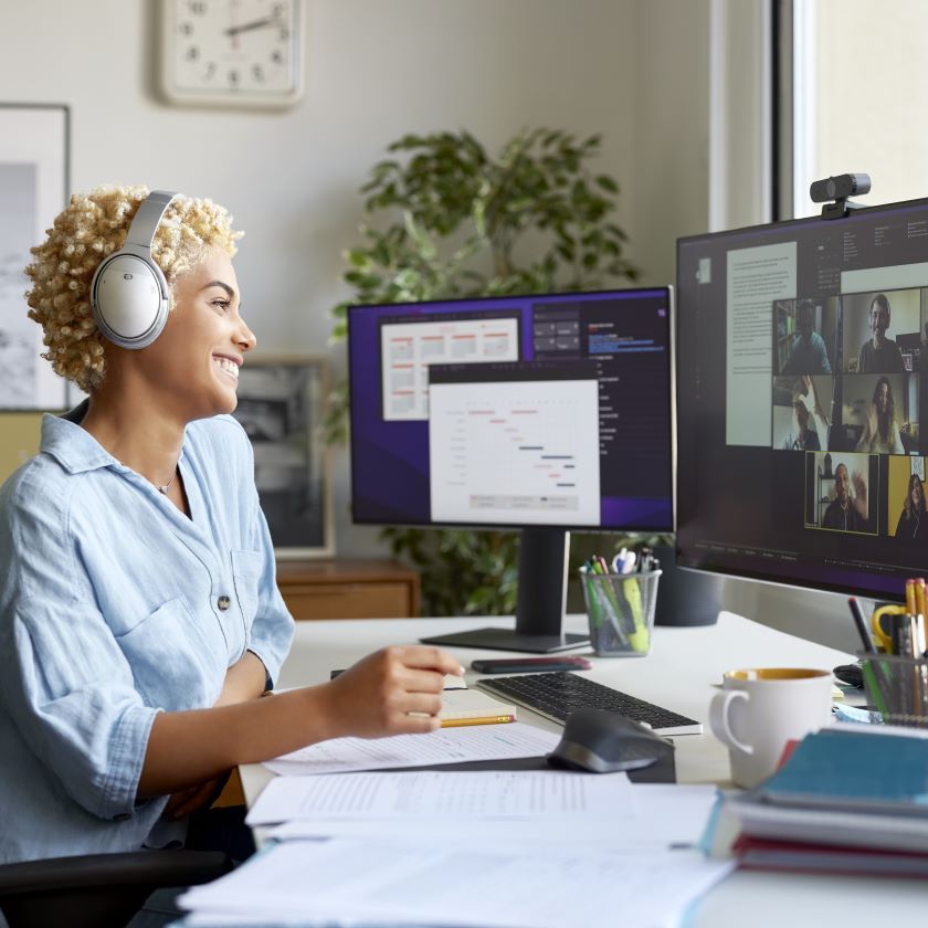 A person sits at their home desk while collaborating with colleagues on a call.