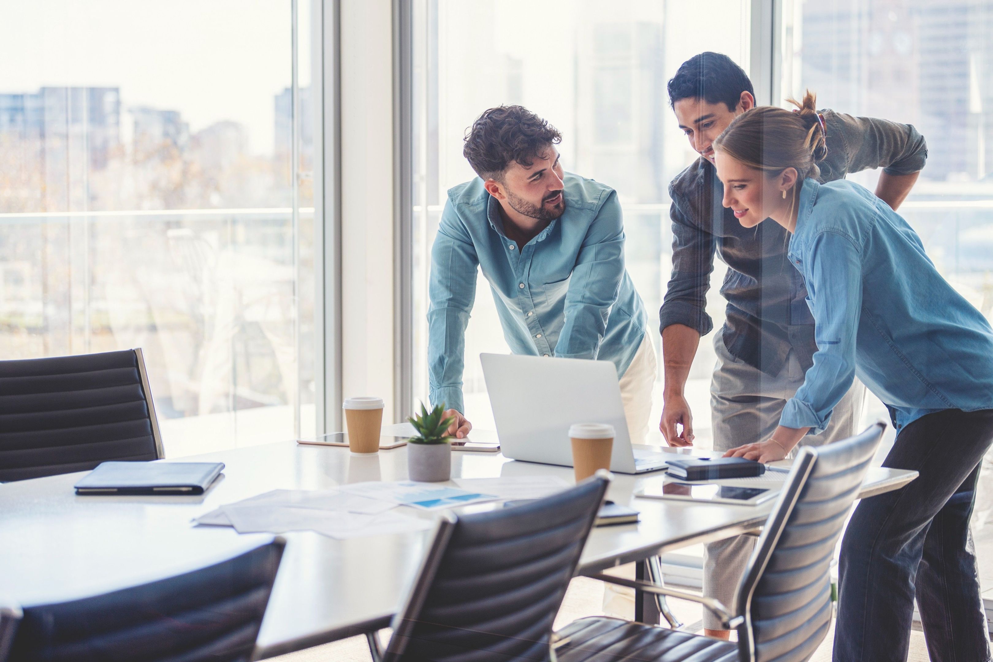 A group of people gather around a meeting table discussing secure cloud storage for business.