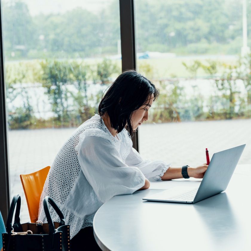 A woman working on a laptop in an office.