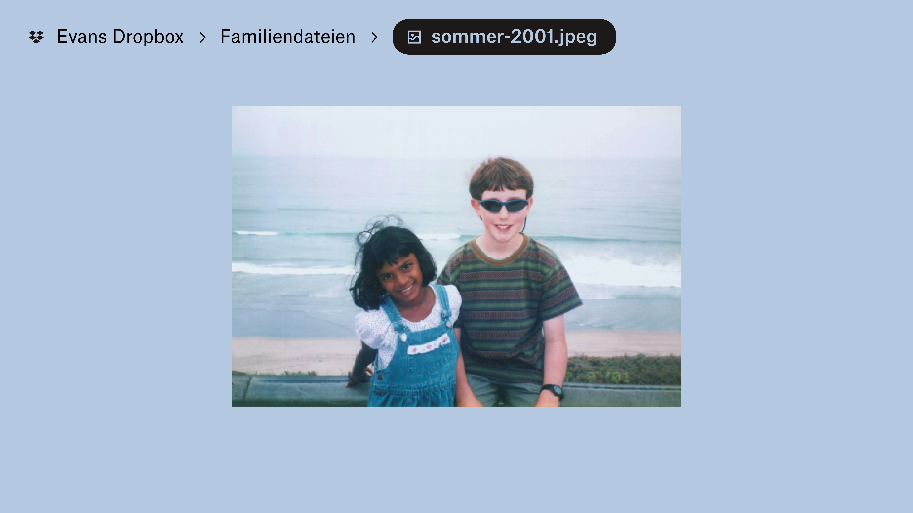 Ein in „Evan‘s Dropbox“ im Ordner „Family Stuff“ gespeichertes Foto. Zwei Kinder lächeln in die Kamera, im Hintergrund sind Wellen am Strand zu sehen.