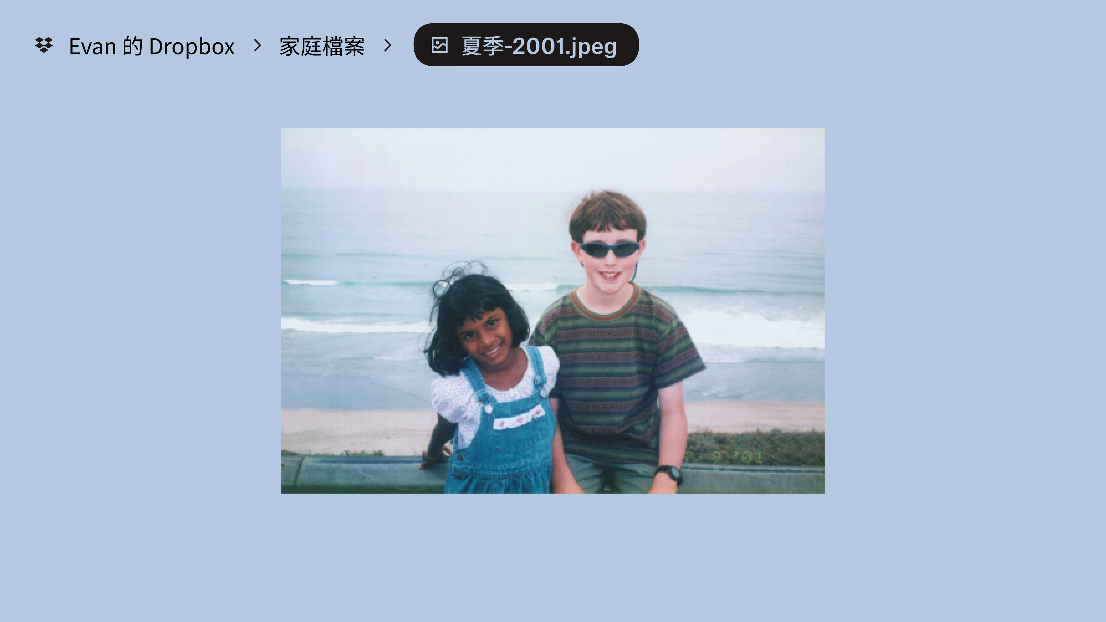 儲存在「Evan’s Dropbox」中「Family Stuff」資料夾中的一張相片。兩名孩童對著鏡頭微笑，背後有沙灘與海浪。