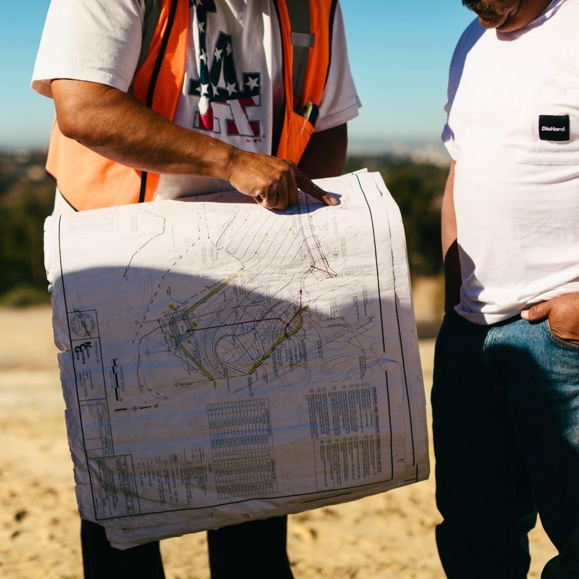 Construction workers looking and pointing at a blueprint