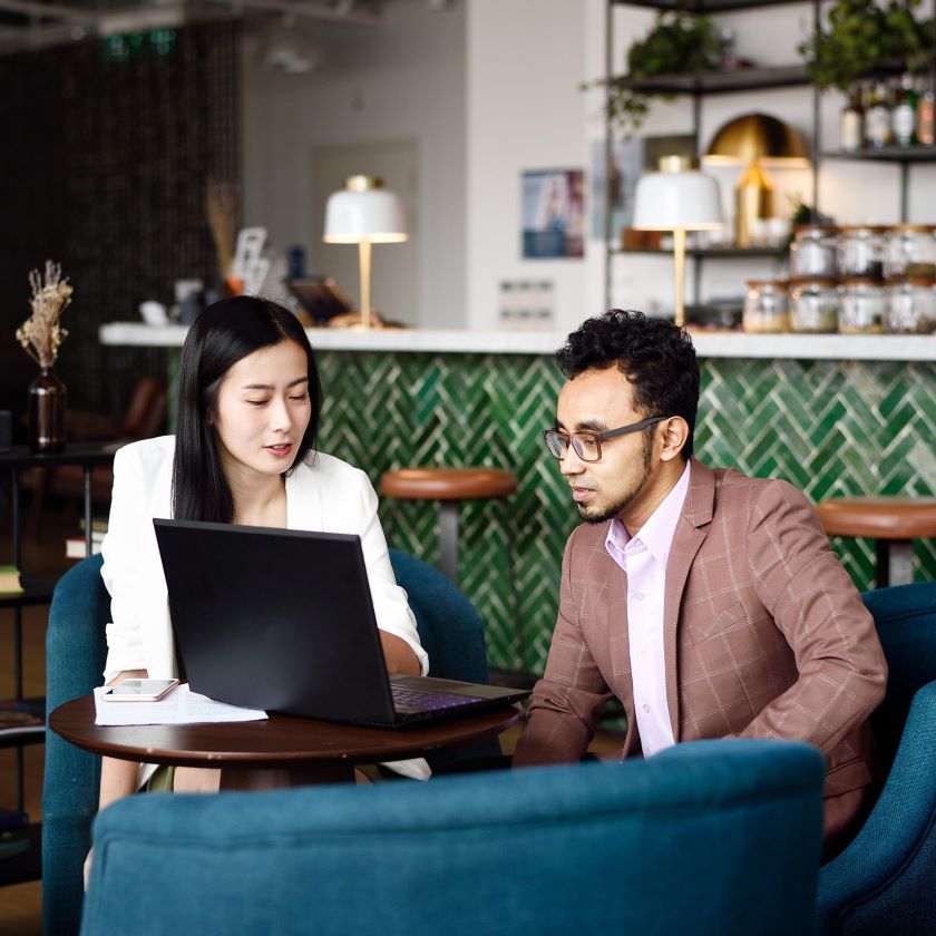Two professionals use digital files to reduce paper waste in the workplace.