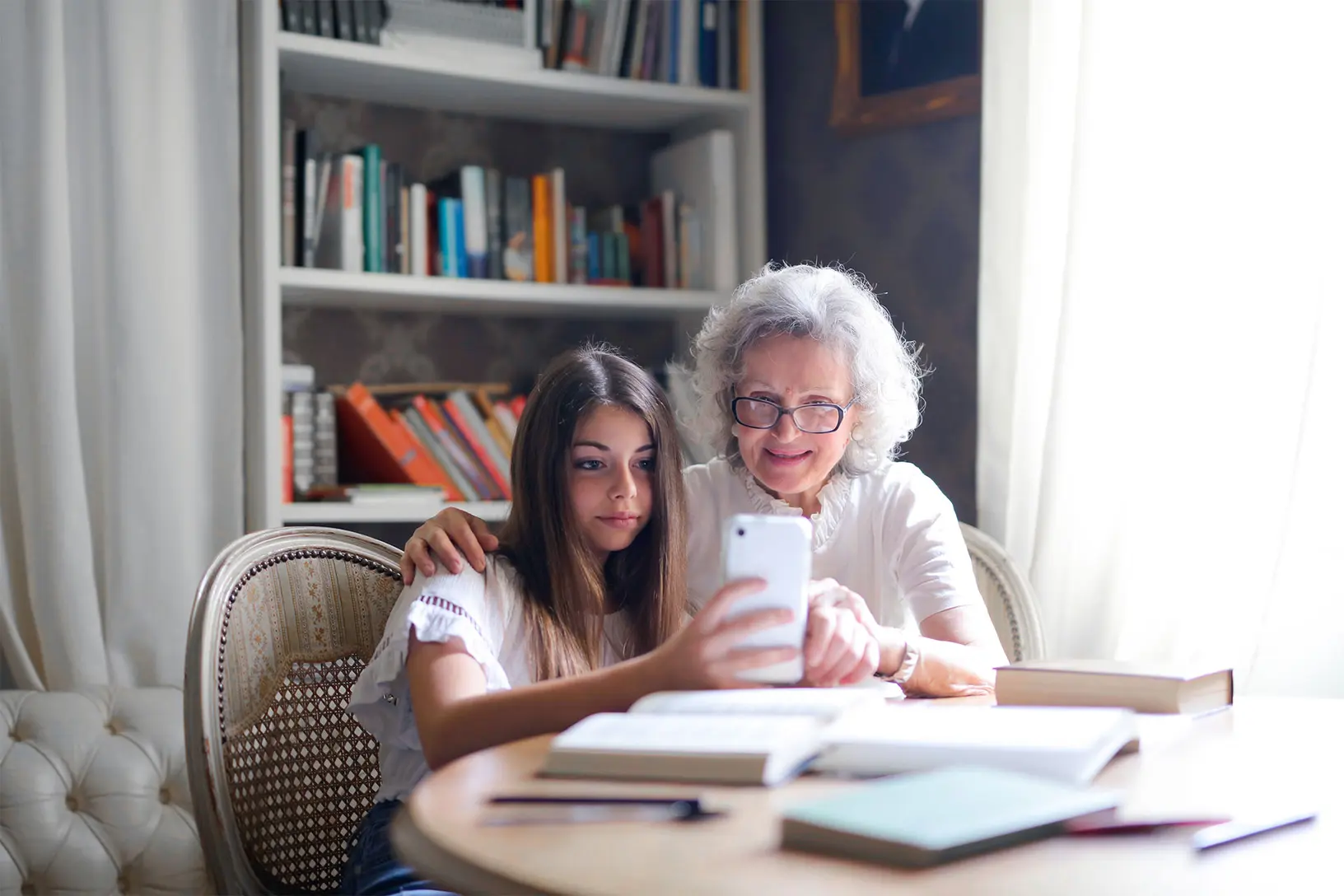 Una persona giovane e una più anziana guardano insieme uno smartphone, a rappresentare l’accesso alle informazioni tramite il cloud computing.