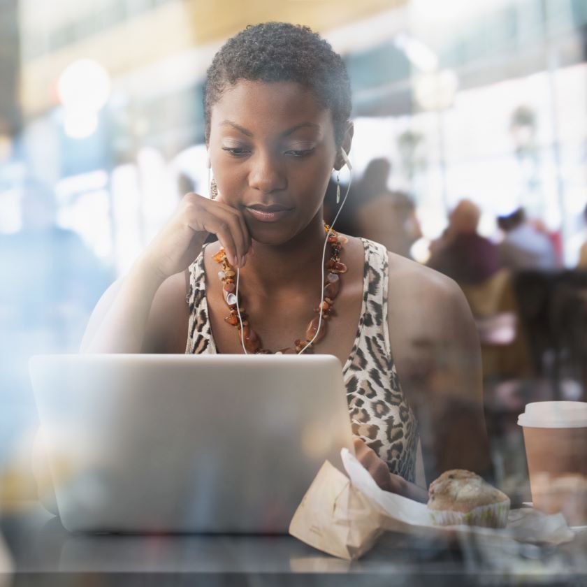 A professional works in a café environment on their secure company device.
