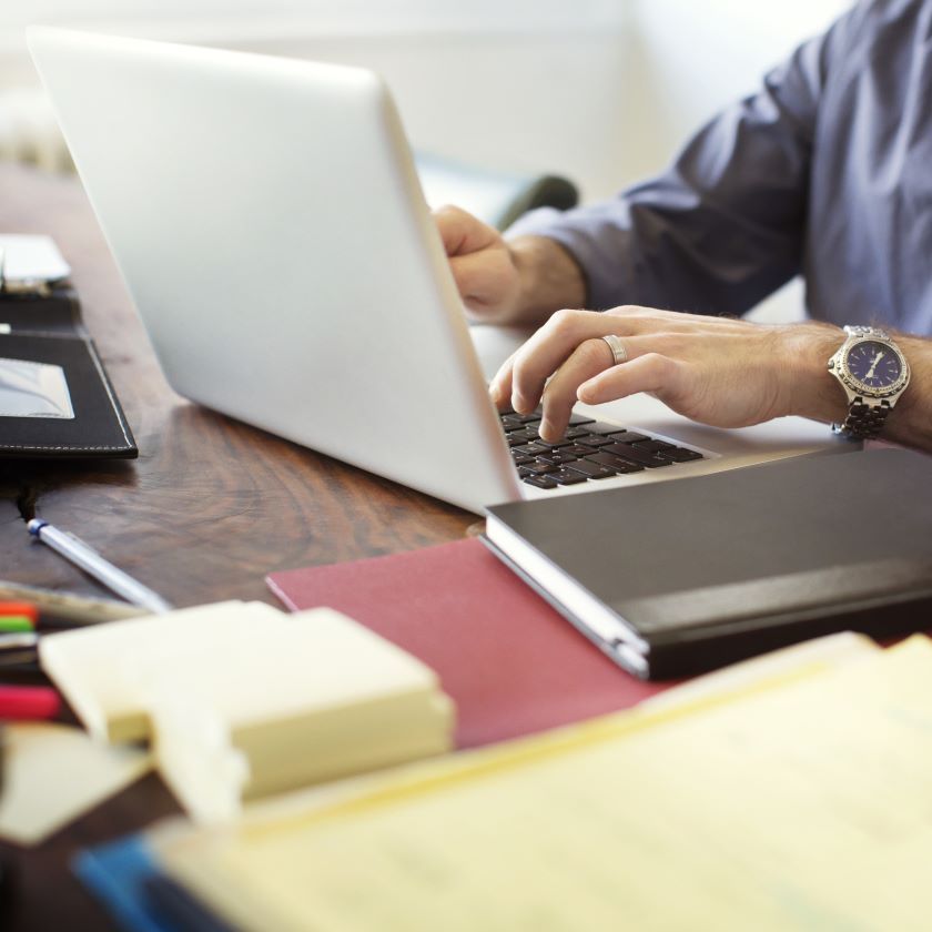 A person creates digital copies of their documents using their laptop.