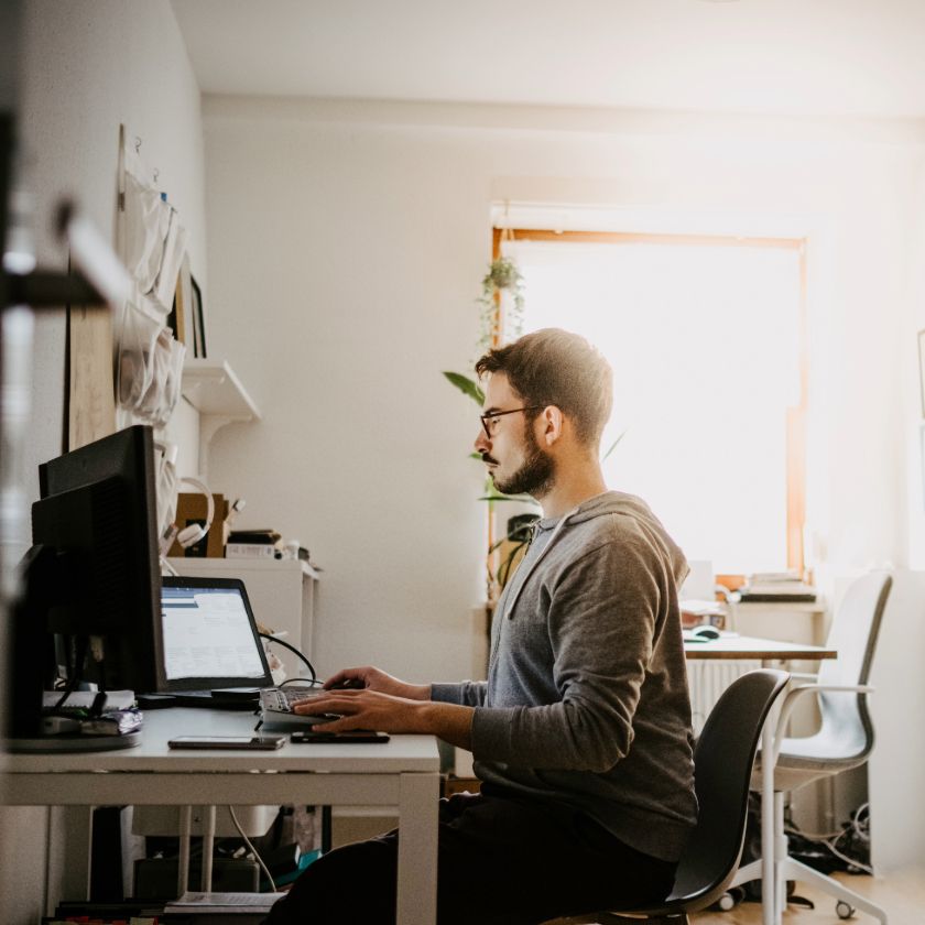 A professional working at a computer in their home office.