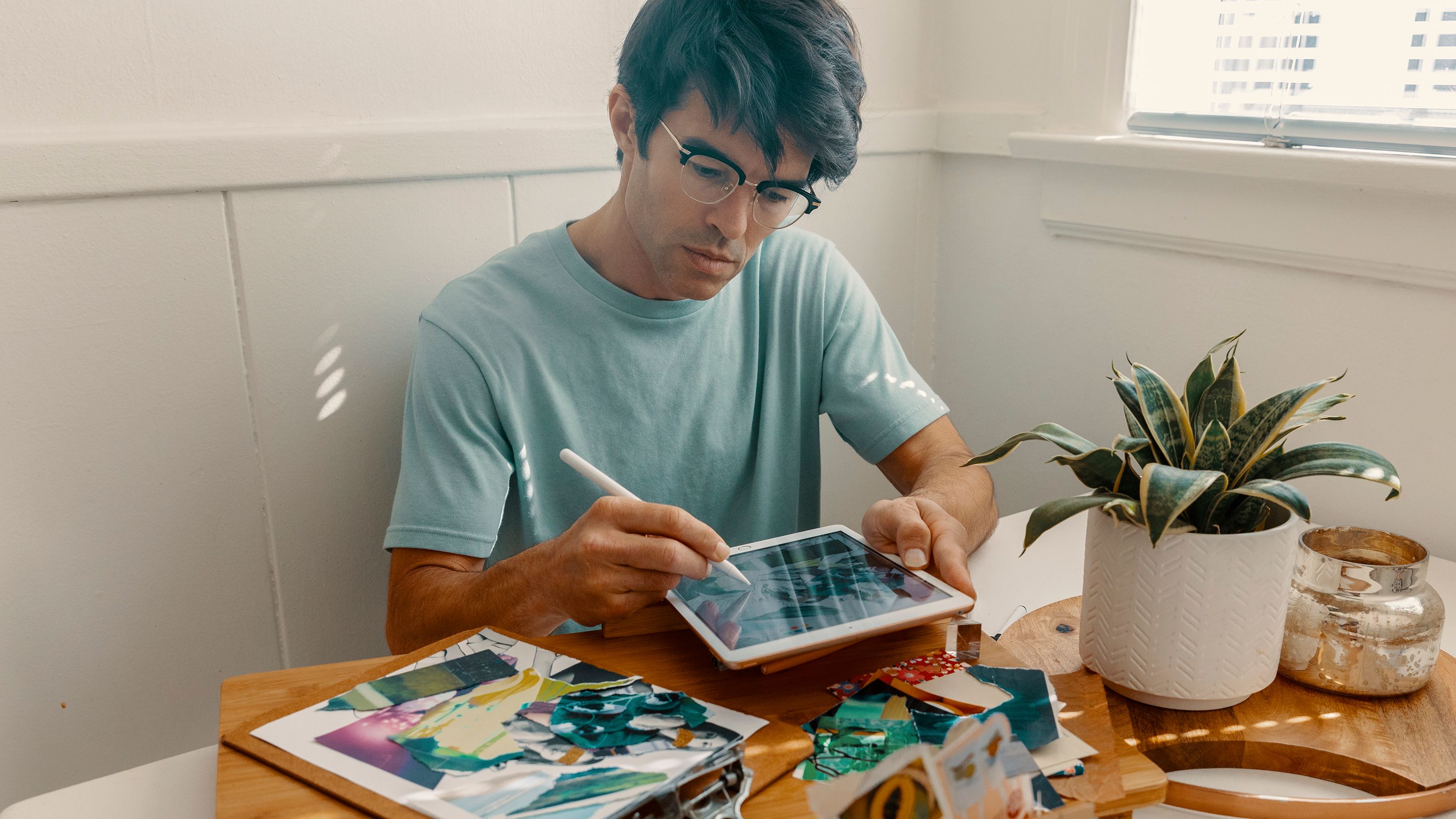 Foto van een grafisch ontwerper die een tablet gebruikt om aan een ontwerpproject te werken.