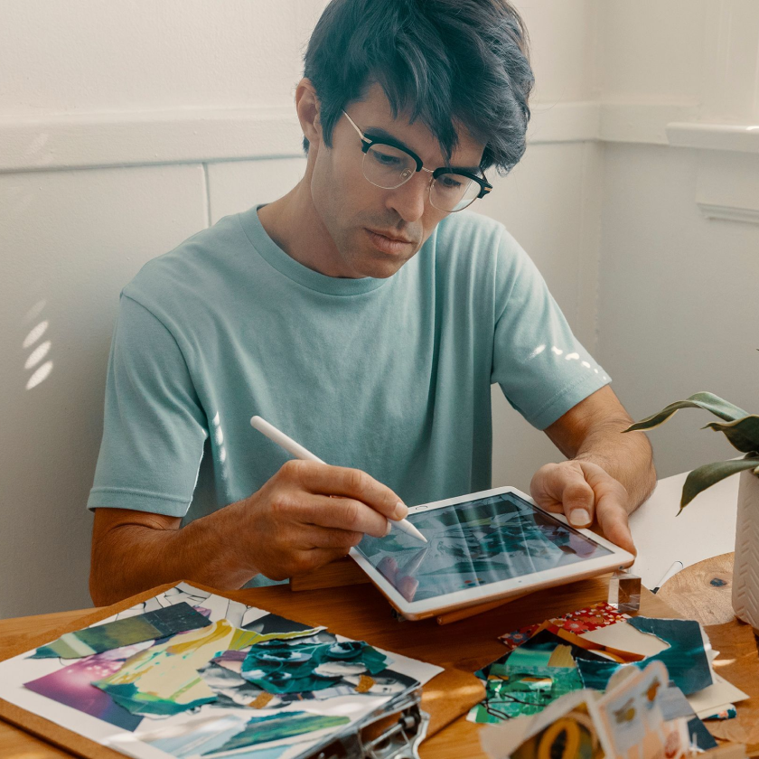 Photograph of a graphic designer using a tablet to work on a design project.